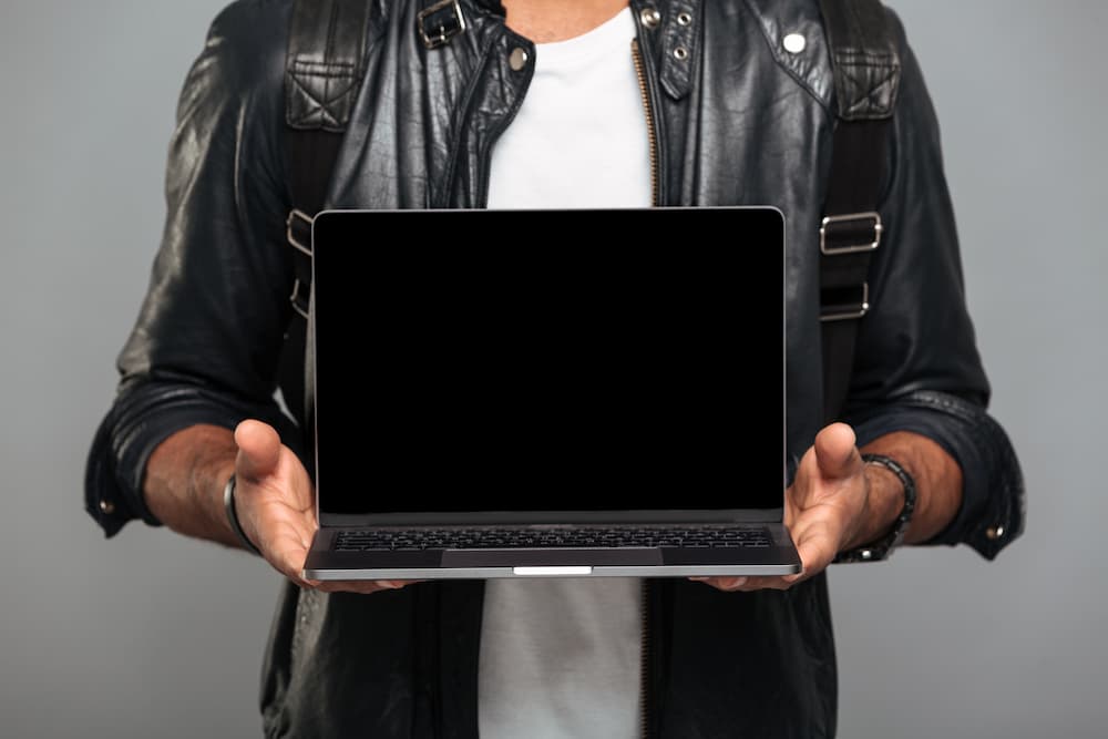 человек в куртке с ноутбуком в руках